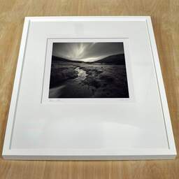 Photographie d'art et collection Denis Olivier, Brook, Lochan Na Bi, Écosse. Avril 2006. Ref-977 - Denis Olivier Photographie, cadre blanc sur une table en bois