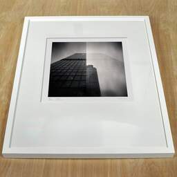Photographie d'art et collection Denis Olivier, City Buildings (double Exposure), London, UK. Avril 2014. Ref-1292 - Denis Olivier Photographie, cadre blanc sur une table en bois
