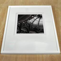 Photographie d'art et collection Denis Olivier, Galeries Lafayette, Paris, France. Février 2005. Ref-545 - Denis Olivier Photographie, cadre blanc sur une table en bois