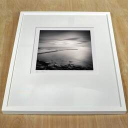 Photographie d'art et collection Denis Olivier, Harbour Piers, Keiss, Écosse. Avril 2006. Ref-964 - Denis Olivier Photographie, cadre blanc sur une table en bois