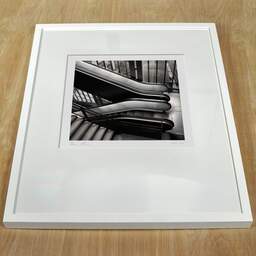 Photographie d'art et collection Denis Olivier, Orsay Museum Escalator, Paris, France. Février 2005. Ref-564 - Denis Olivier Photographie, cadre blanc sur une table en bois