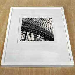 Photographie d'art et collection Denis Olivier, Orsay Museum Glass Roof I, Paris, France. Février 2005. Ref-561 - Denis Olivier Photographie, cadre blanc sur une table en bois