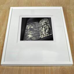Photographie d'art et collection Denis Olivier, Stained-Glass Window, Surgères, France. Mars 1990. Ref-987 - Denis Olivier Photographie, cadre blanc sur une table en bois