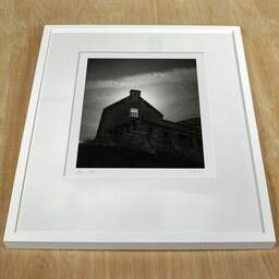 Photographie d'art et collection Denis Olivier, Sun Behind The Window, Edinburgh Castle, Écosse. Août 2022. Ref-11647 - Denis Olivier Photographie, cadre blanc sur une table en bois