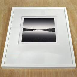 Photographie d'art et collection Denis Olivier, Water Mirror, Loch Garry, Écosse. Août 2022. Ref-11579 - Denis Olivier Photographie, cadre blanc sur une table en bois