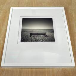 Art and collection photography Denis Olivier, Bench, LLandulas Beach, Wales. April 2006. Ref-947 - Denis Olivier Photography, white frame on a wooden table