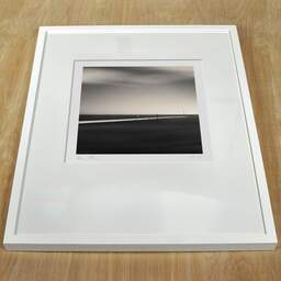 Art and collection photography Denis Olivier, Beyond The Horizon, Brittany, France. August 2005. Ref-1127 - Denis Olivier Photography, white frame on a wooden table