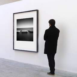 Art and collection photography Denis Olivier, Breakwaters, Etude 1, Sant-Feliu De Guixols, Spain. November 2007. Ref-1116 - Denis Olivier Art Photography, A visitor contemplate a large original photographic art print in limited edition and signed in a black frame