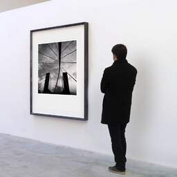 Art and collection photography Denis Olivier, Bridge And Buildings, Bilbao, Spain. February 2022. Ref-11532 - Denis Olivier Art Photography, A visitor contemplate a large original photographic art print in limited edition and signed in a black frame