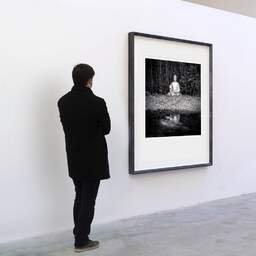 Art and collection photography Denis Olivier, Buddha, Royan, France. July 2022. Ref-11560 - Denis Olivier Art Photography, A visitor contemplate a large original photographic art print in limited edition and signed in a black frame