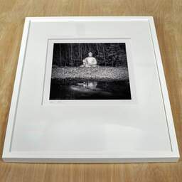 Art and collection photography Denis Olivier, Buddha, Royan, France. July 2022. Ref-11560 - Denis Olivier Art Photography, white frame on a wooden table