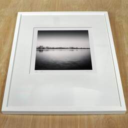 Art and collection photography Denis Olivier, City Skyline, Bordeaux-Lake, France. April 2021. Ref-11471 - Denis Olivier Photography, white frame on a wooden table