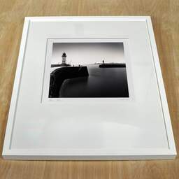 Art and collection photography Denis Olivier, East And West Jetty Lighthouses, Saint-Nazaire, France. August 2020. Ref-1425 - Denis Olivier Art Photography, white frame on a wooden table