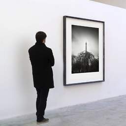 Art and collection photography Denis Olivier, Eiffel Tower, Park And Gardens, Paris, France. February 2023. Ref-11678 - Denis Olivier Art Photography, A visitor contemplate a large original photographic art print in limited edition and signed in a black frame