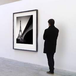 Art and collection photography Denis Olivier, Eiffel Tower Sunrise, Paris, France. February 2022. Ref-11625 - Denis Olivier Art Photography, A visitor contemplate a large original photographic art print in limited edition and signed in a black frame