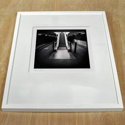 Art and collection photography Denis Olivier, Escalator, Saint-Jean Train Station, France. April 2021. Ref-11505 - Denis Olivier Photography, white frame on a wooden table