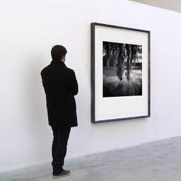 Art and collection photography Denis Olivier, François Soula Lake, Plaisance-du-Touch, France. June 2021. Ref-11453 - Denis Olivier Art Photography, A visitor contemplate a large original photographic art print in limited edition and signed in a black frame
