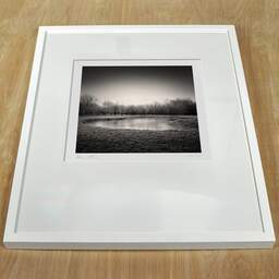 Art and collection photography Denis Olivier, Frozen Pond, Coperit, France. December 2005. Ref-894 - Denis Olivier Photography, white frame on a wooden table