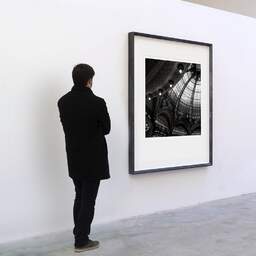 Art and collection photography Denis Olivier, Galeries Lafayette, Paris, France. February 2005. Ref-545 - Denis Olivier Art Photography, A visitor contemplate a large original photographic art print in limited edition and signed in a black frame
