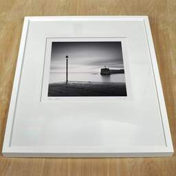 Art and collection photography Denis Olivier, Harbour Entrance, Bourcefranc-Le-Chapus, France. November 2021. Ref-11554 - Denis Olivier Photography, white frame on a wooden table