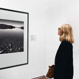 Art and collection photography Denis Olivier, Immersed Stones, Loch Garry, Scotland. August 2022. Ref-11595 - Denis Olivier Art Photography, A woman contemplate a large original photographic art print in limited edition and signed in a black frame