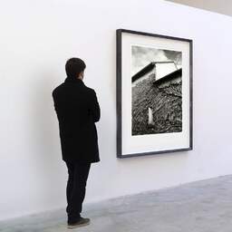 Art and collection photography Denis Olivier, Ivy House, Royan, France. December 2023. Ref-11655 - Denis Olivier Photography, A visitor contemplate a large original photographic art print in limited edition and signed in a black frame