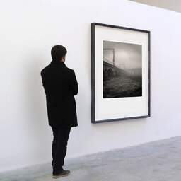Art and collection photography Denis Olivier, Junction Way, Arveyres, France. November 2005. Ref-827 - Denis Olivier Art Photography, A visitor contemplate a large original photographic art print in limited edition and signed in a black frame