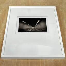 Art and collection photography Denis Olivier, Moving In A Tunnel, Highway A83, France. August 2020. Ref-1391 - Denis Olivier Photography, white frame on a wooden table