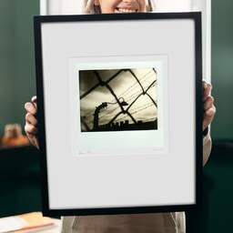 Art and collection photography Denis Olivier, Never Again, Auschwitz-Birkenau II Camp, Poland. July 2015. Ref-1307 - Denis Olivier Photography, original 9 x 9 inches fine-art photograph print in limited edition and signed hold by a galerist woman