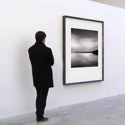 Art and collection photography Denis Olivier, Pier Tréhic, Etude 1, Le Croisic, France. May 2021. Ref-11444 - Denis Olivier Art Photography, A visitor contemplate a large original photographic art print in limited edition and signed in a black frame
