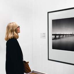 Art and collection photography Denis Olivier, Pont De Pierre Bridge And St. Michael Basilica Tower, Bordeaux, France. September 2020. Ref-1365 - Denis Olivier Art Photography, A woman contemplate a large original photographic art print in limited edition and signed in a black frame