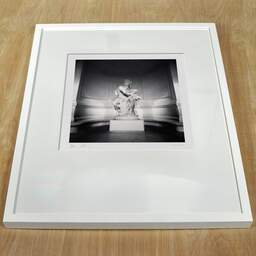 Art and collection photography Denis Olivier, Protection And Future Statue, Palais Galliera, Paris, France. February 2022. Ref-11530 - Denis Olivier Photography, white frame on a wooden table