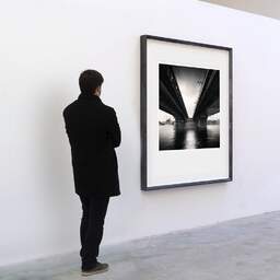 Art and collection photography Denis Olivier, Rákóczi Bridge, Budapest, Hungary. June 2019. Ref-1372 - Denis Olivier Art Photography, A visitor contemplate a large original photographic art print in limited edition and signed in a black frame