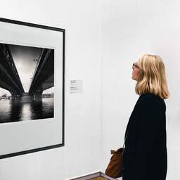 Art and collection photography Denis Olivier, Rákóczi Bridge, Budapest, Hungary. June 2019. Ref-1372 - Denis Olivier Art Photography, A woman contemplate a large original photographic art print in limited edition and signed in a black frame