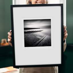 Art and collection photography Denis Olivier, Ramp, Breakwater And Pier, Le Croisic, France. May 2021. Ref-11445 - Denis Olivier Art Photography, original 9 x 9 inches fine-art photograph print in limited edition and signed hold by a galerist woman