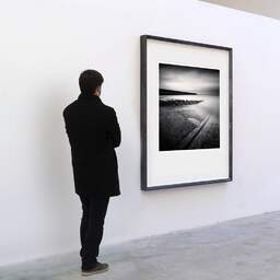 Art and collection photography Denis Olivier, Ramp, Breakwater And Pier, Le Croisic, France. May 2021. Ref-11445 - Denis Olivier Art Photography, A visitor contemplate a large original photographic art print in limited edition and signed in a black frame