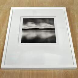 Art and collection photography Denis Olivier, Reflecting Clouds, Sauvages Lake, France. August 2020. Ref-1422 - Denis Olivier Art Photography, white frame on a wooden table