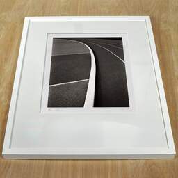 Art and collection photography Denis Olivier, Running Track, Leo Lagrange Stadium, Saint-Nazaire, France. November 2022. Ref-11621 - Denis Olivier Photography, white frame on a wooden table