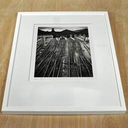 Art and collection photography Denis Olivier, Saint-Lazare Rail Station, Paris, France. February 2022. Ref-11679 - Denis Olivier Art Photography, white frame on a wooden table