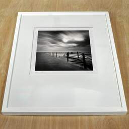 Art and collection photography Denis Olivier, Seafront, Ramsgate Beach, England. April 2006. Ref-973 - Denis Olivier Photography, white frame on a wooden table