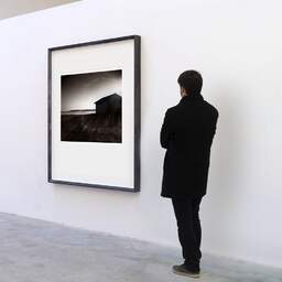 Art and collection photography Denis Olivier, Shed By The Lake, Etude 2, Carreyre, Lacanau Lake, France. January 2021. Ref-11610 - Denis Olivier Art Photography, A visitor contemplate a large original photographic art print in limited edition and signed in a black frame
