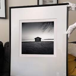 Art and collection photography Denis Olivier, Shed By The Lake, Etude 1, Carreyre, Lacanau Lake, France. January 2021. Ref-1408 - Denis Olivier Photography, large original 9 x 9 inches fine-art photograph print in limited edition and signed hold by a galerist woman