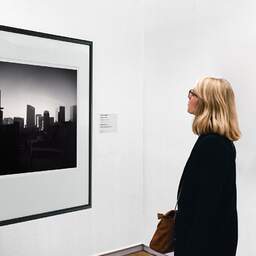 Art and collection photography Denis Olivier, Skyline, Osaka, Japan. July 2014. Ref-11572 - Denis Olivier Art Photography, A woman contemplate a large original photographic art print in limited edition and signed in a black frame