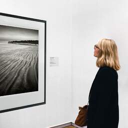Art and collection photography Denis Olivier, Suzac Beach, Meschers-sur-Gironde, France. February 2023. Ref-11668 - Denis Olivier Art Photography, A woman contemplate a large original photographic art print in limited edition and signed in a black frame