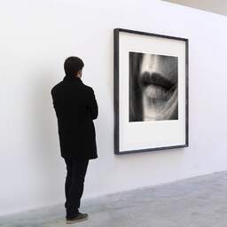Art and collection photography Denis Olivier, Sweet On Her Lips, Bordeaux, France. April 2005. Ref-580 - Denis Olivier Art Photography, A visitor contemplate a large original photographic art print in limited edition and signed in a black frame