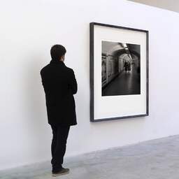 Art and collection photography Denis Olivier, Tunnel Of Life, Metro, Paris, France. February 2005. Ref-566 - Denis Olivier Art Photography, A visitor contemplate a large original photographic art print in limited edition and signed in a black frame