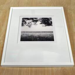 Art and collection photography Denis Olivier, Windy Fields, Le Croisic, France. April 2022. Ref-11556 - Denis Olivier Photography, white frame on a wooden table
